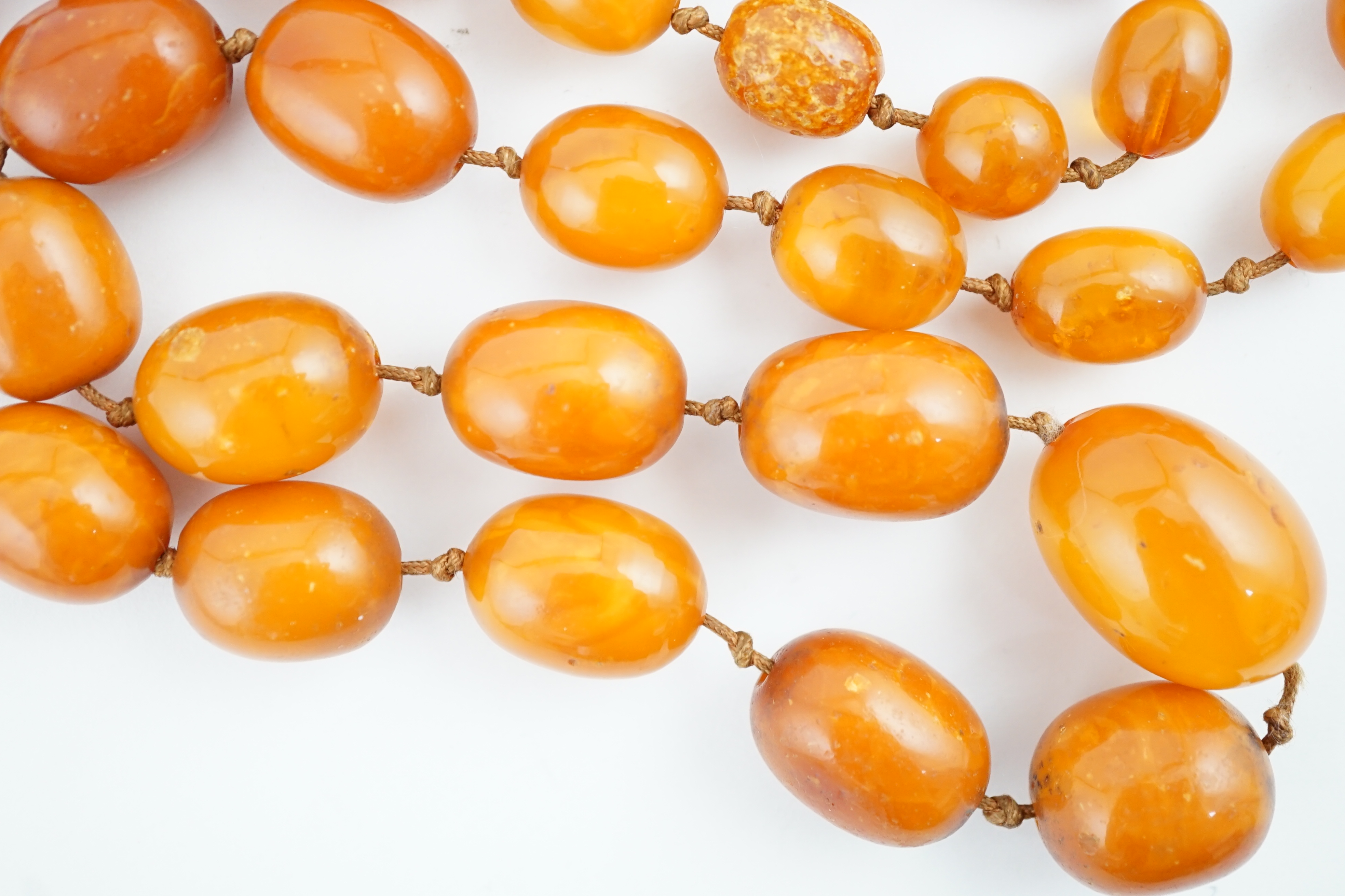 A long single strand graduated amber bead necklace